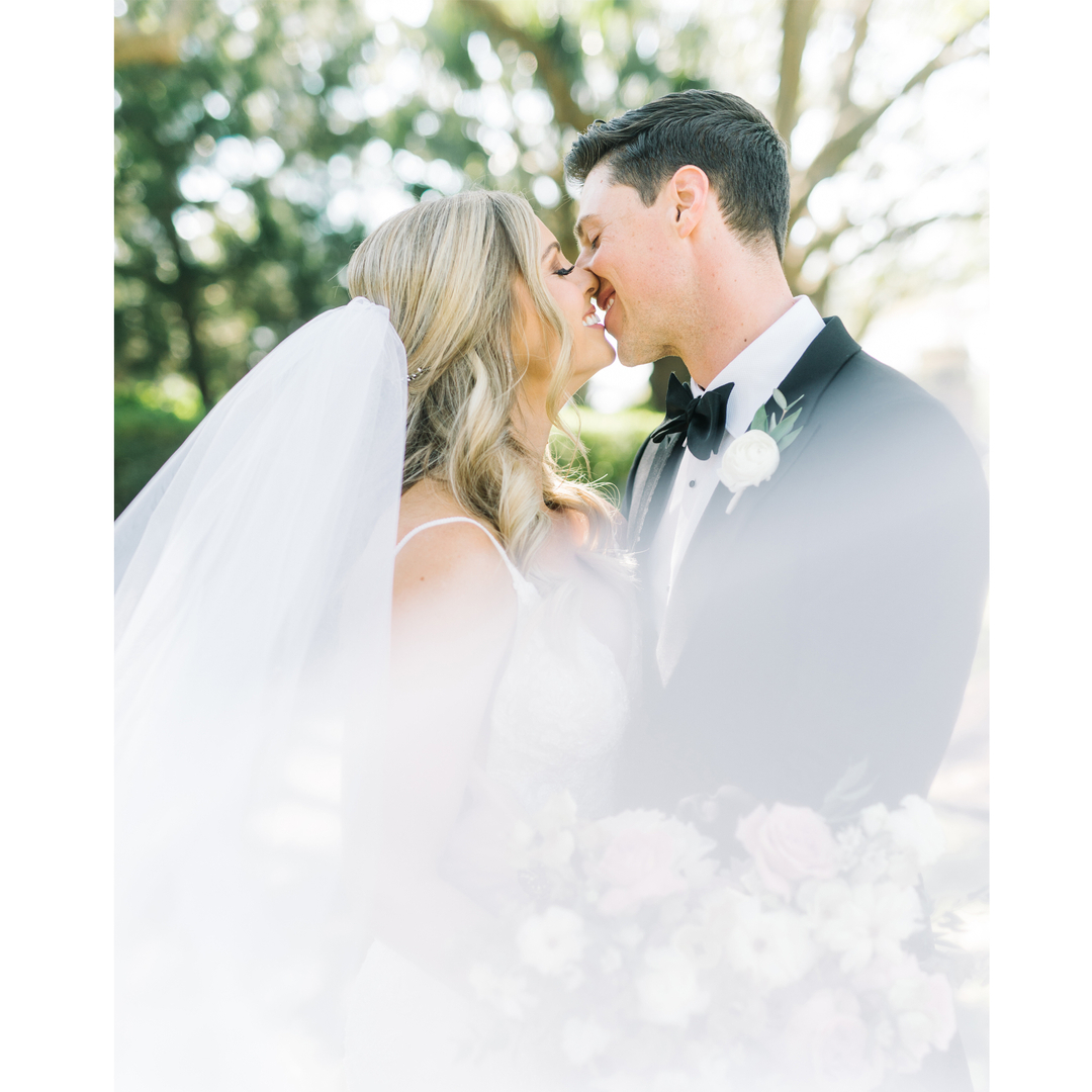Newlyweds sharing a quiet kiss, bride's veil framing the moment