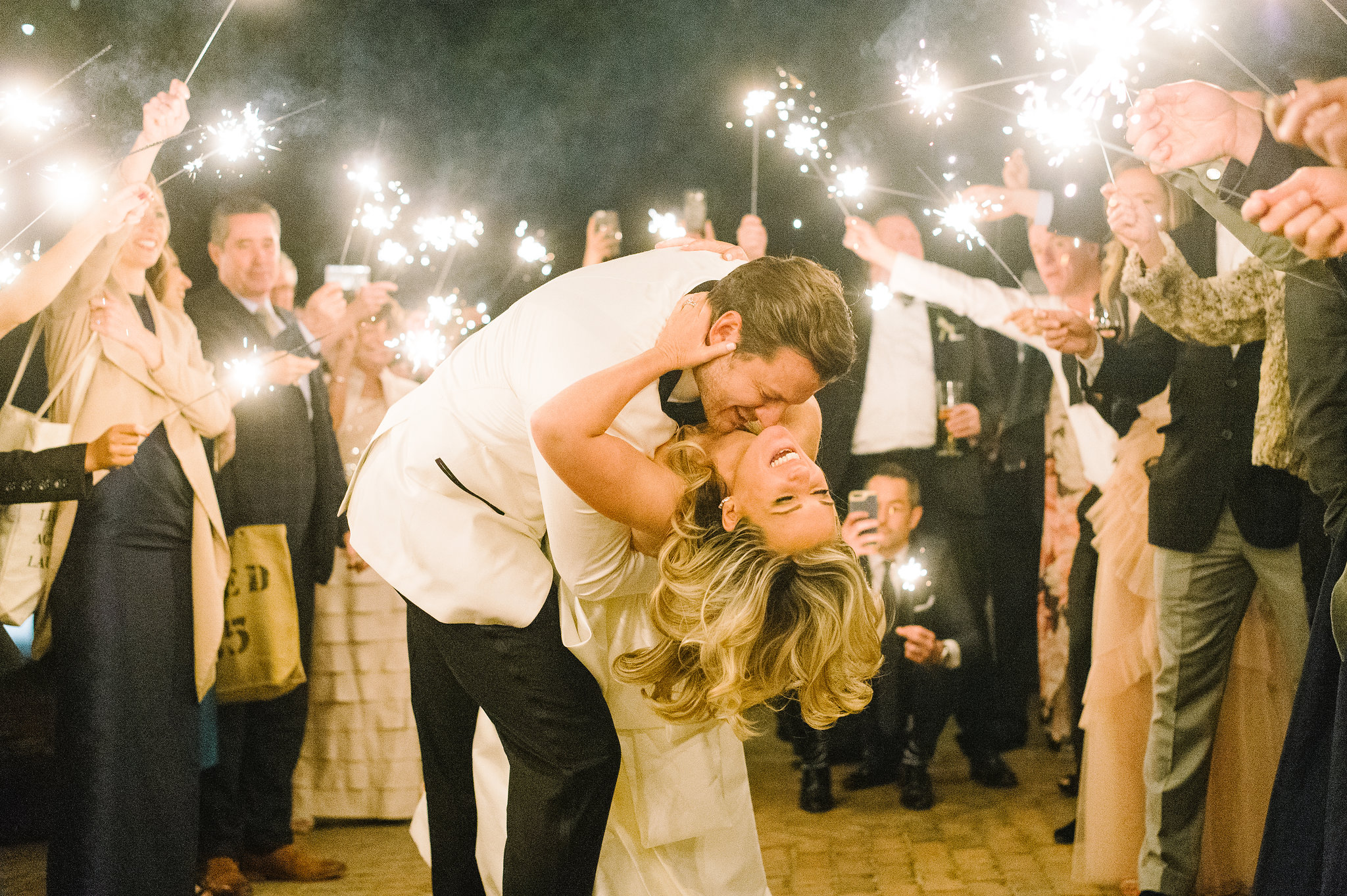 Joyful sparkler send-off as the couple shares a kiss