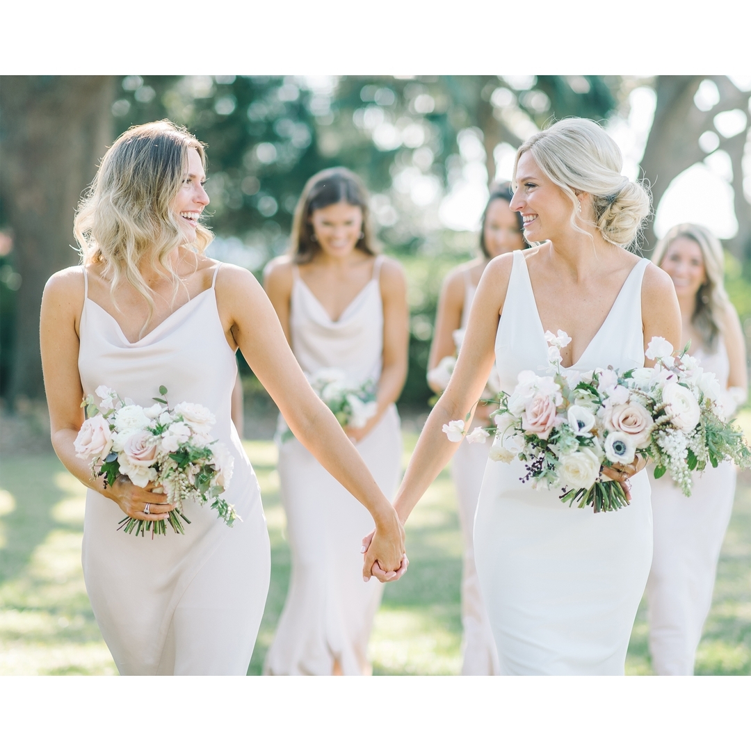 Bride and her wedding party walking together, holding hands